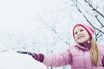 Image showing Happy little girl playing  on winter snow day.