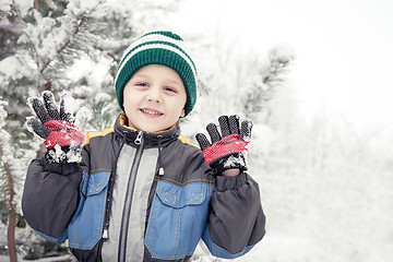 Image showing Happy little boy playing  on winter snow day.