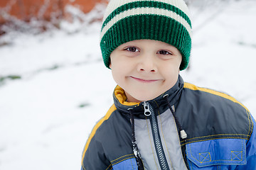 Image showing Happy little boy playing  on winter snow day.