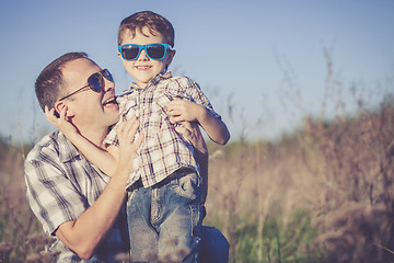 Image showing Father and son playing on the field at the day time.