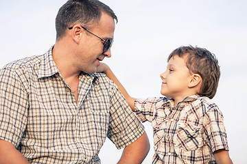 Image showing Father and son playing on the field at the day time.