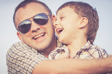 Image showing Father and son playing on the beach at the sunset time.