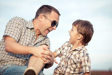 Image showing Father and son playing on the field at the day time.