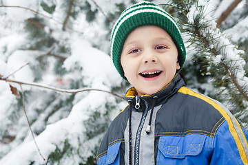 Image showing Happy little boy playing  on winter snow day.