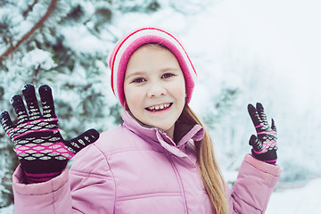 Image showing Happy little girl playing  on winter snow day.