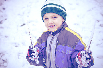 Image showing Happy little boy playing  on winter snow day.