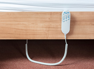 Image showing Bed remote hanging at the side from a bed