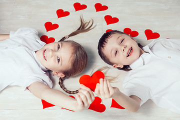 Image showing  little boy and girl lying on the floor.