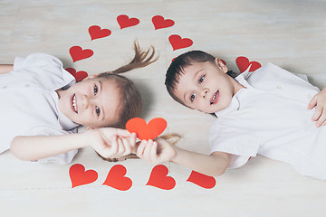 Image showing little boy and girl lying on the floor.