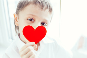 Image showing One little boy standing near a window. 