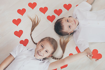 Image showing little boy and girl lying on the floor.