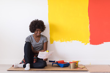 Image showing back female painter sitting on floor