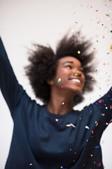 Image showing African American woman blowing confetti in the air