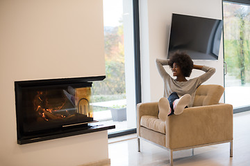 Image showing black woman in front of fireplace