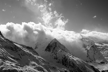 Image showing Black and white view on snow sunlight mountains in clouds