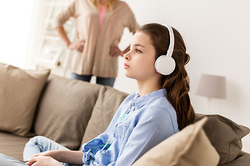 Image showing girl with earphones and angry mother at home