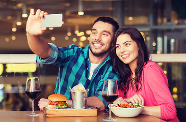 Image showing couple taking selfie by smartphone at restaurant