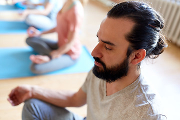 Image showing man with group of people meditating at yoga studio