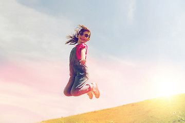 Image showing happy little girl jumping high outdoors