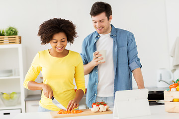 Image showing happy couple cooking food at home kitchen