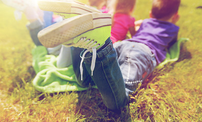 Image showing close up of kids lying on picnic blanket outdoors