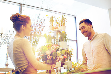 Image showing smiling florist woman and man at flower shop