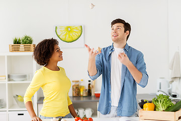 Image showing couple cooking food and juggling garlic at home