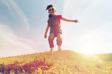 Image showing happy little girl jumping high outdoors