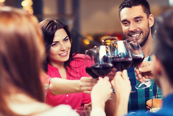 Image showing friends clinking glasses of wine at restaurant