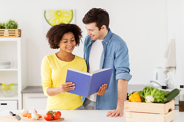 Image showing happy couple with cooking book at home kitchen