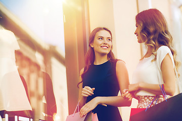 Image showing happy women with shopping bags at shop window