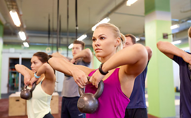 Image showing group of people with kettlebells exercising in gym