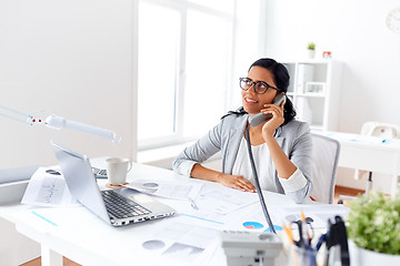 Image showing businesswoman calling on desk phone at office