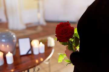 Image showing woman with roses and cremation urn at funeral