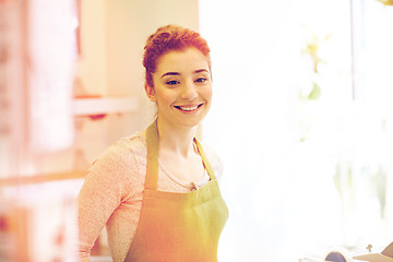 Image showing smiling florist woman or gardener at flower shop