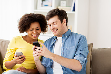 Image showing happy couple with smartphones at home