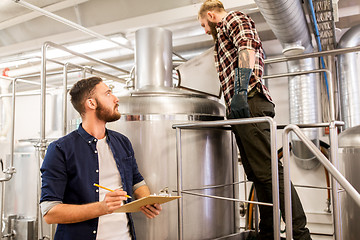 Image showing men with clipboard at craft brewery or beer plant