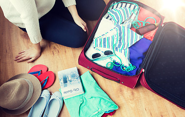 Image showing close up of woman packing travel bag for vacation