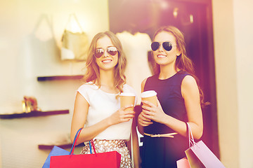 Image showing young women with shopping bags and coffee at shop