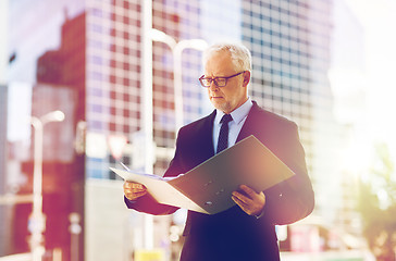 Image showing senior businessman with ring binder folder in city