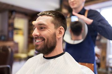 Image showing man and hairdresser with mirror at barbershop