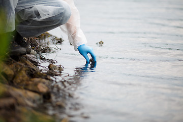 Image showing Human takes sample of water