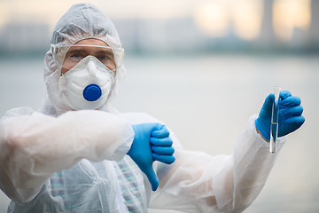 Image showing Biologist in respirator with test-tube