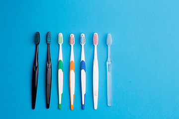 Image showing Multi-colored toothbrushes on blue background