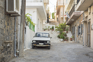 Image showing Old rusty white car parked in the street