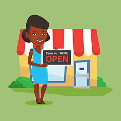 Image showing Female shop owner holding open signboard.