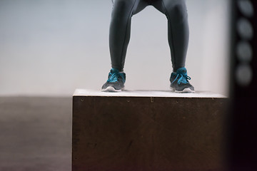 Image showing black woman is performing box jumps at gym