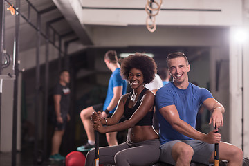 Image showing multiethnic couple after workout with hammer