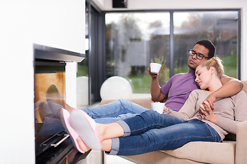 Image showing Young multiethnic couple  in front of fireplace