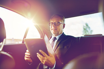 Image showing senior businessman with tablet pc driving in car